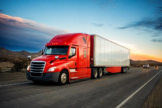 A Red Truck drives down the highway.