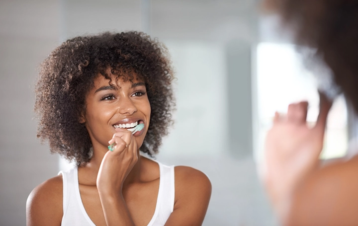 Lady happily brushing teeth